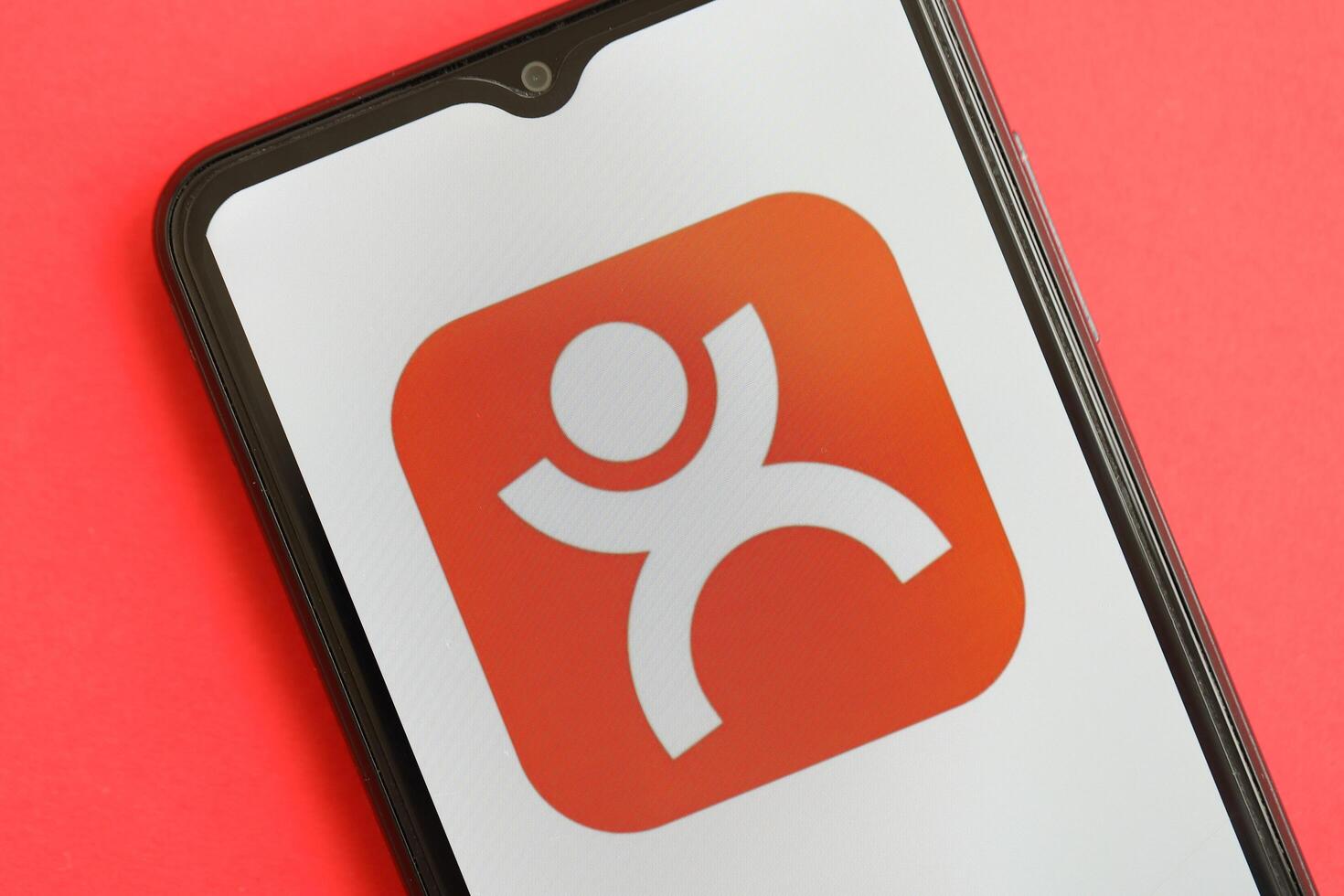 KYIV, UKRAINE - APRIL 1, 2024 Dianping platform icon on smartphone screen on red table photo