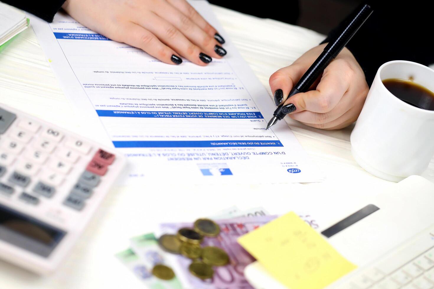 KYIV, UKRAINE - OCTOBER 31, 2023 Accountant fill french tax form 3916 Declaration by resident of account opened, held used or closed abroad in end of tax period. Taxation and paperwork photo