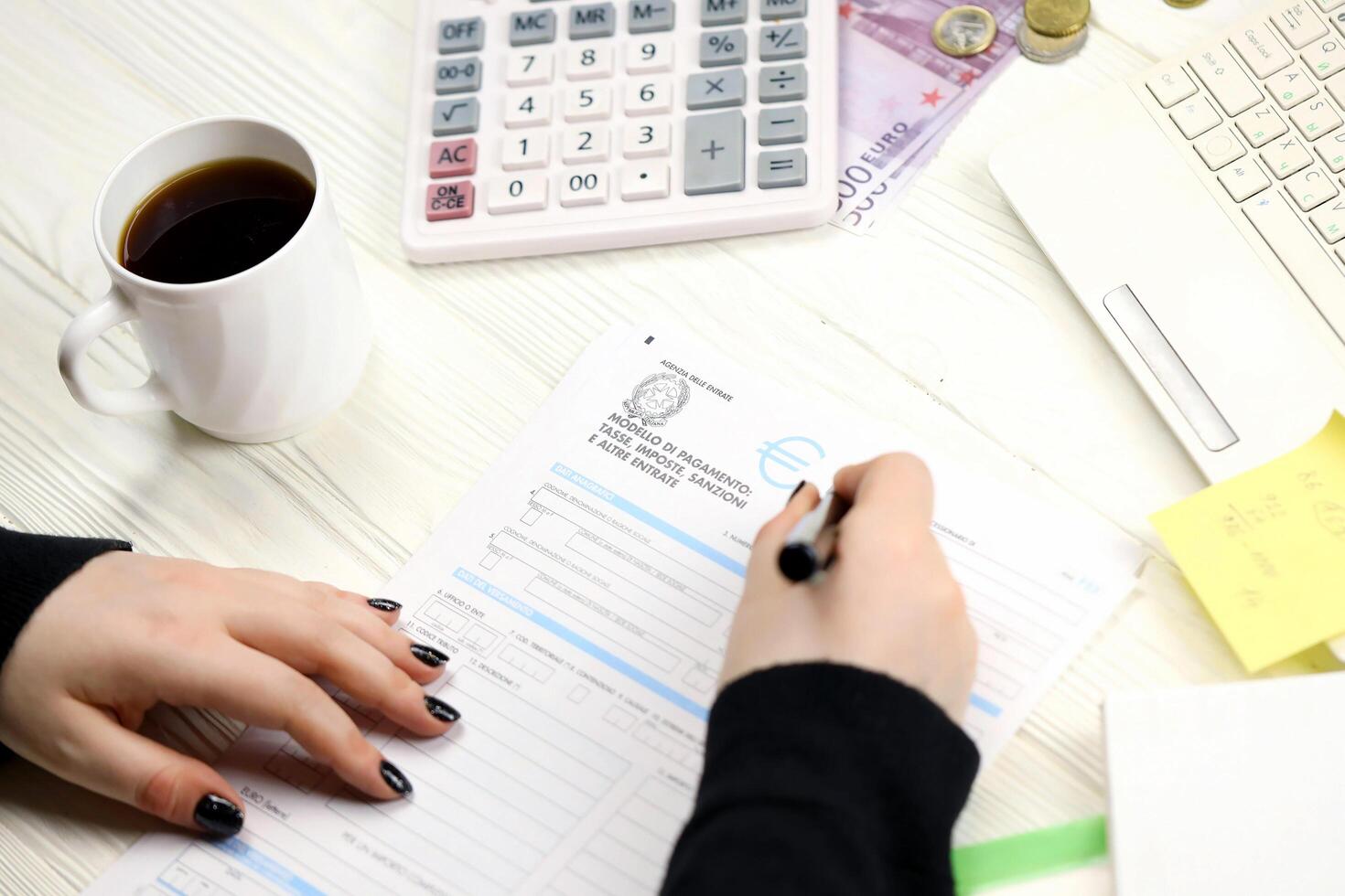 KYIV, UKRAINE - OCTOBER 31, 2023 Accountant fill italian tax form F23 Payment model taxes duties penalties and other revenues in end of tax period. Taxation and paperwork routine photo