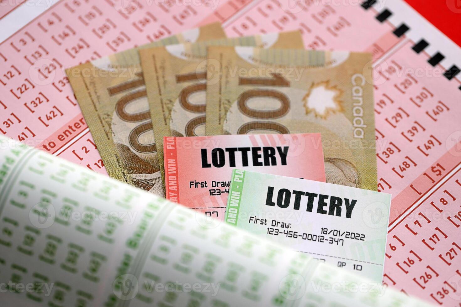 Lottery tickets lies with canadian dollars on gambling sheets with numbers for marking to play lottery photo