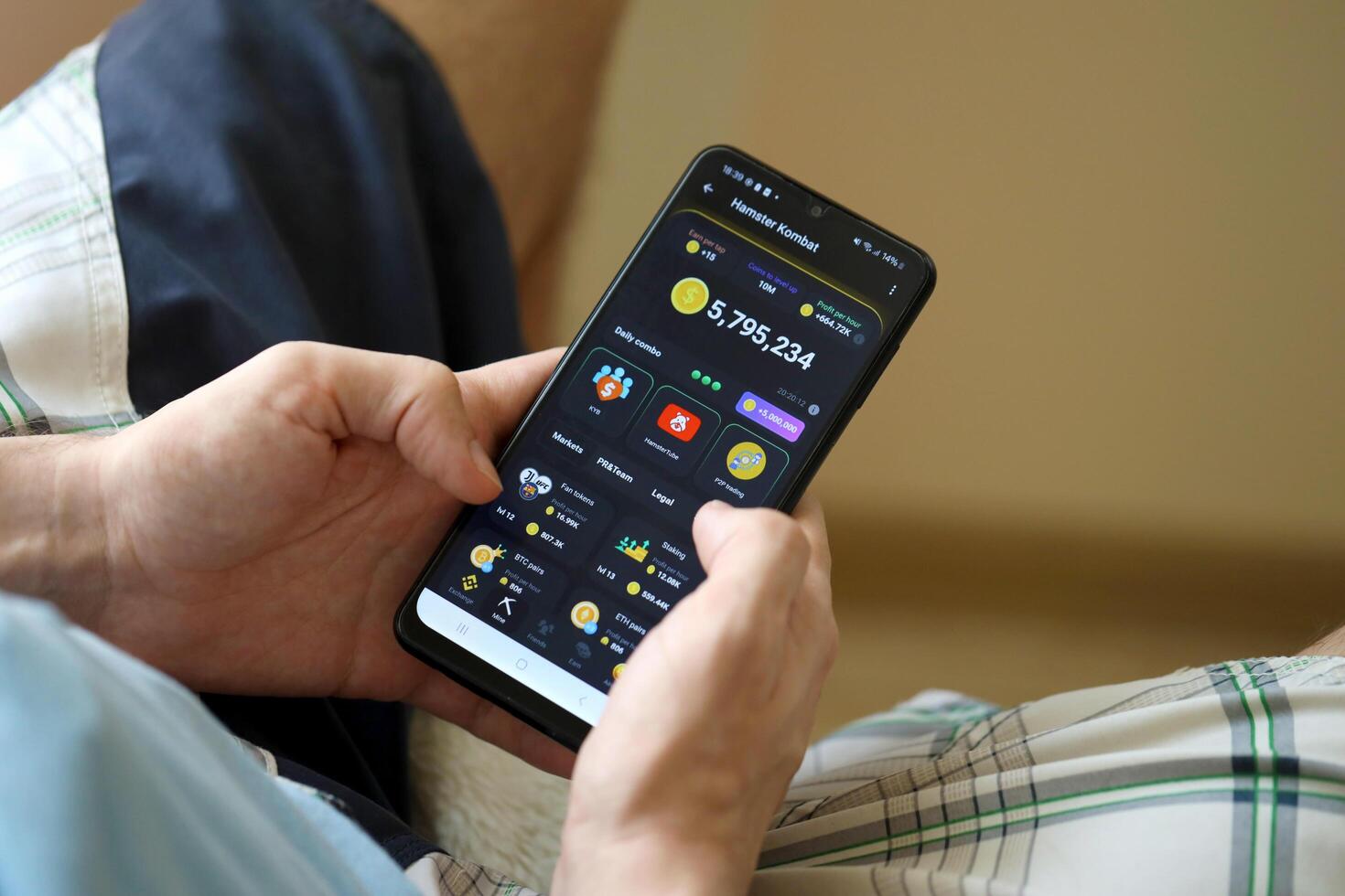 KYIV, UKRAINE - APRIL 20, 2024 Hamster Kombat telegram bot on smartphone screen. Hamster Kombat is a viral Telegram crypto game for earn HMSTR tokens by managing virtual crypto exchange photo