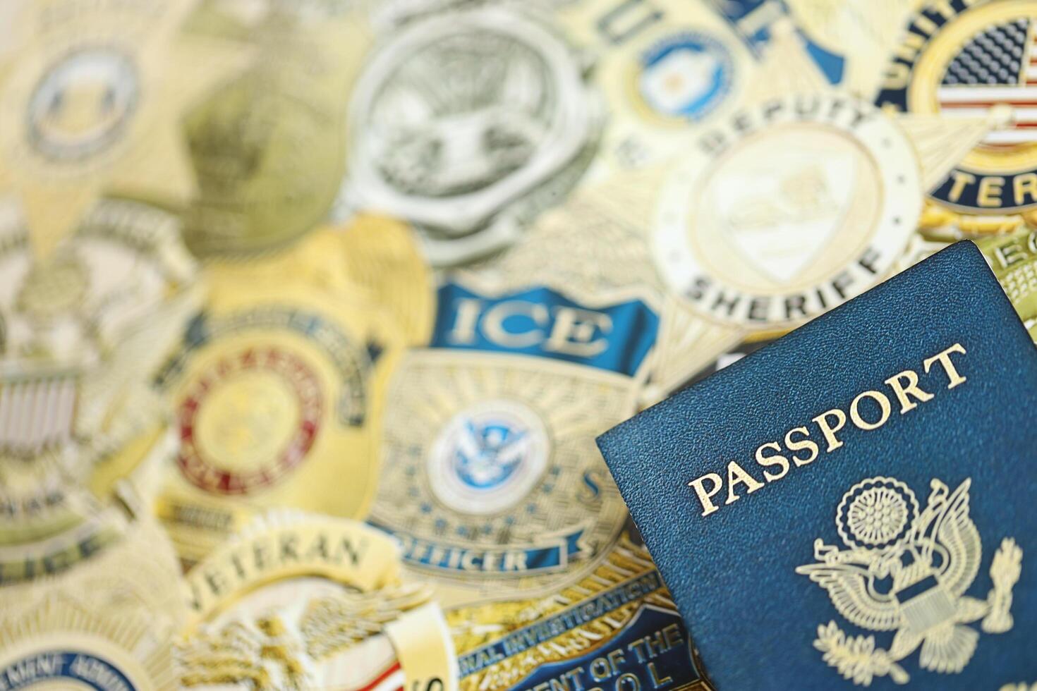 KYIV, UKRAINE - MARCH 9, 2024 US Passport lies on badges of different United States police departments printed on paper photo