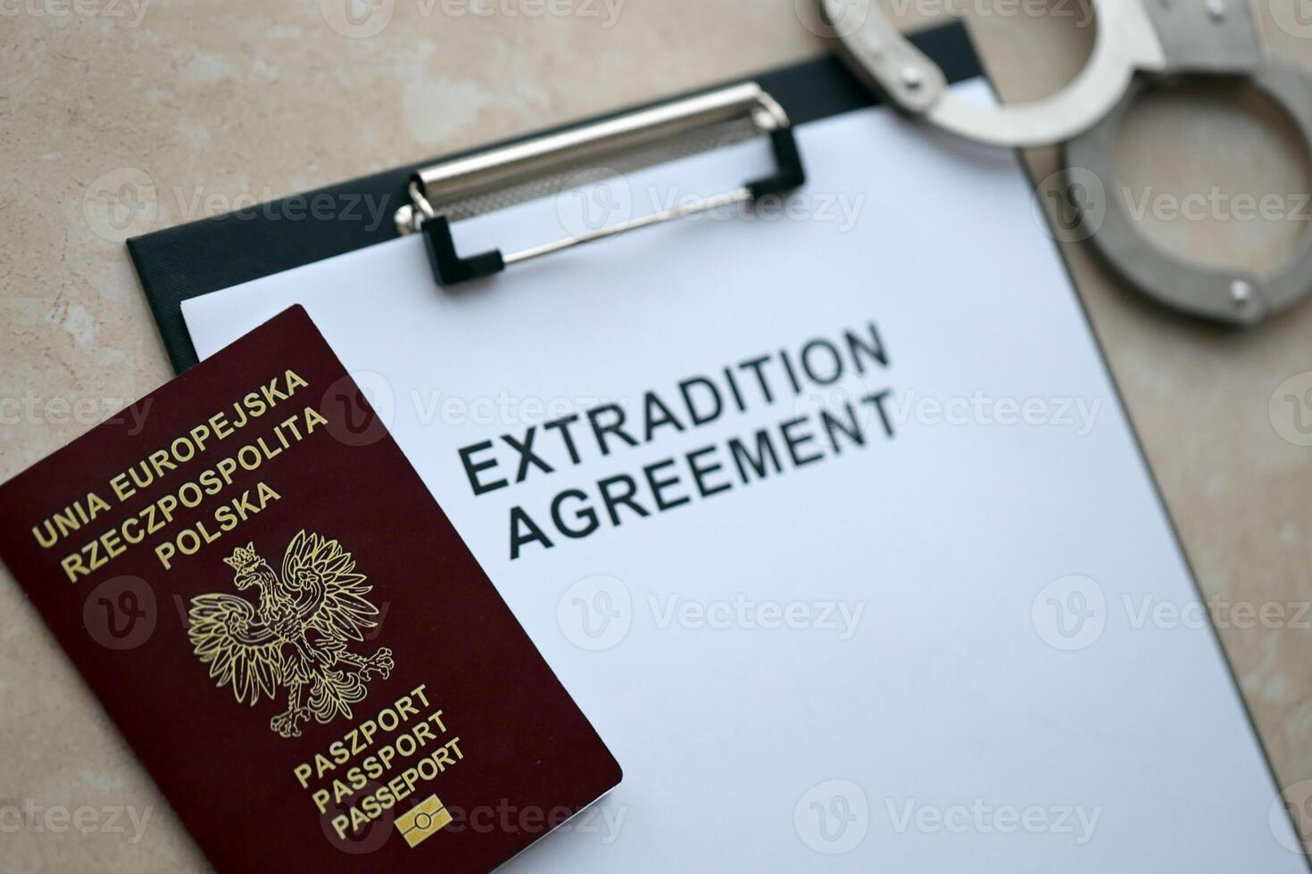 Passport of Poland and Extradition Agreement with handcuffs on table photo