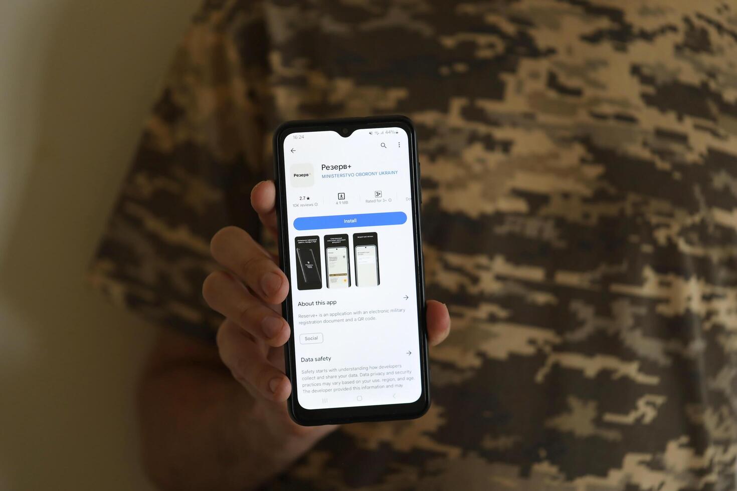 KYIV, UKRAINE - JUNE 20, 2024 Hand holds smartphone with Rezerv plus - ukrainian application for smartphone with actual personal information about conscript status photo