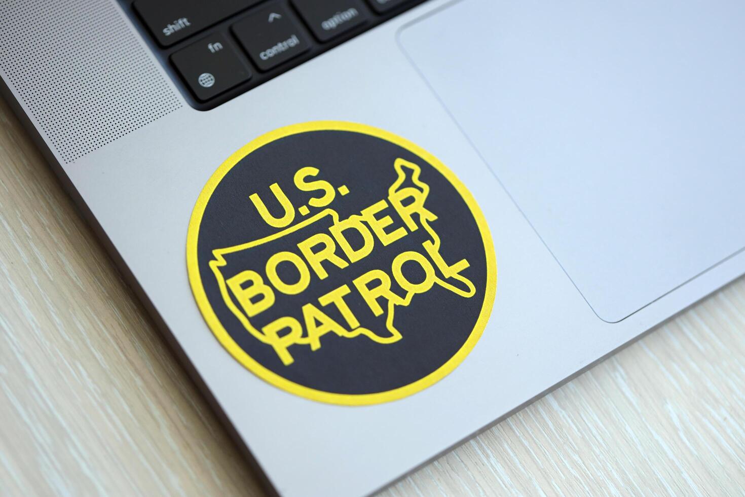 KYIV, UKRAINE - JUNE 26, 2024 U.S. Border Patrol coat of arms sticker on silver laptop photo