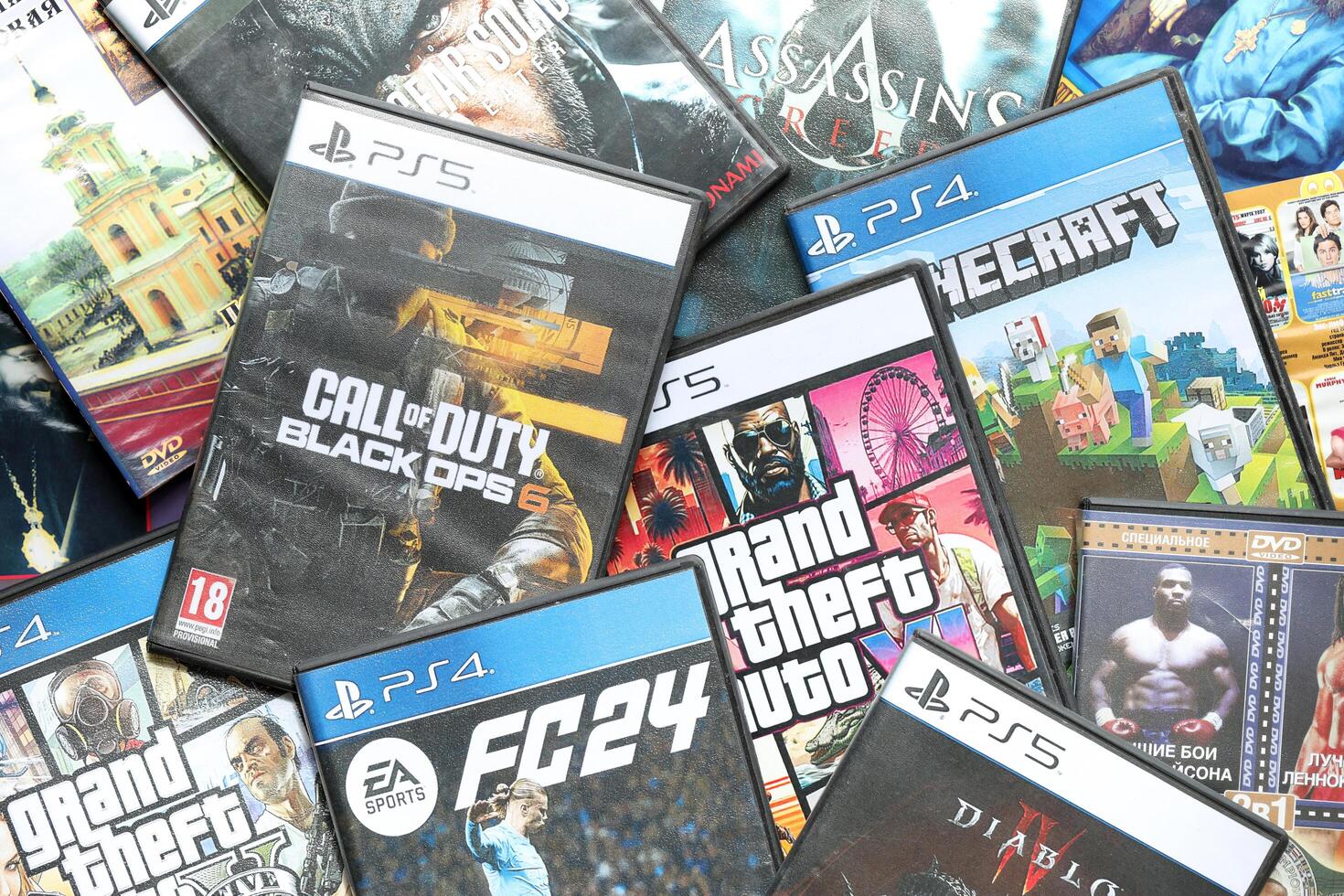 KYIV, UKRAINE - JUNE 26, 2024 Stack of games for Sony Playstation 5 and 4 console. Many disc boxes of popular games photo