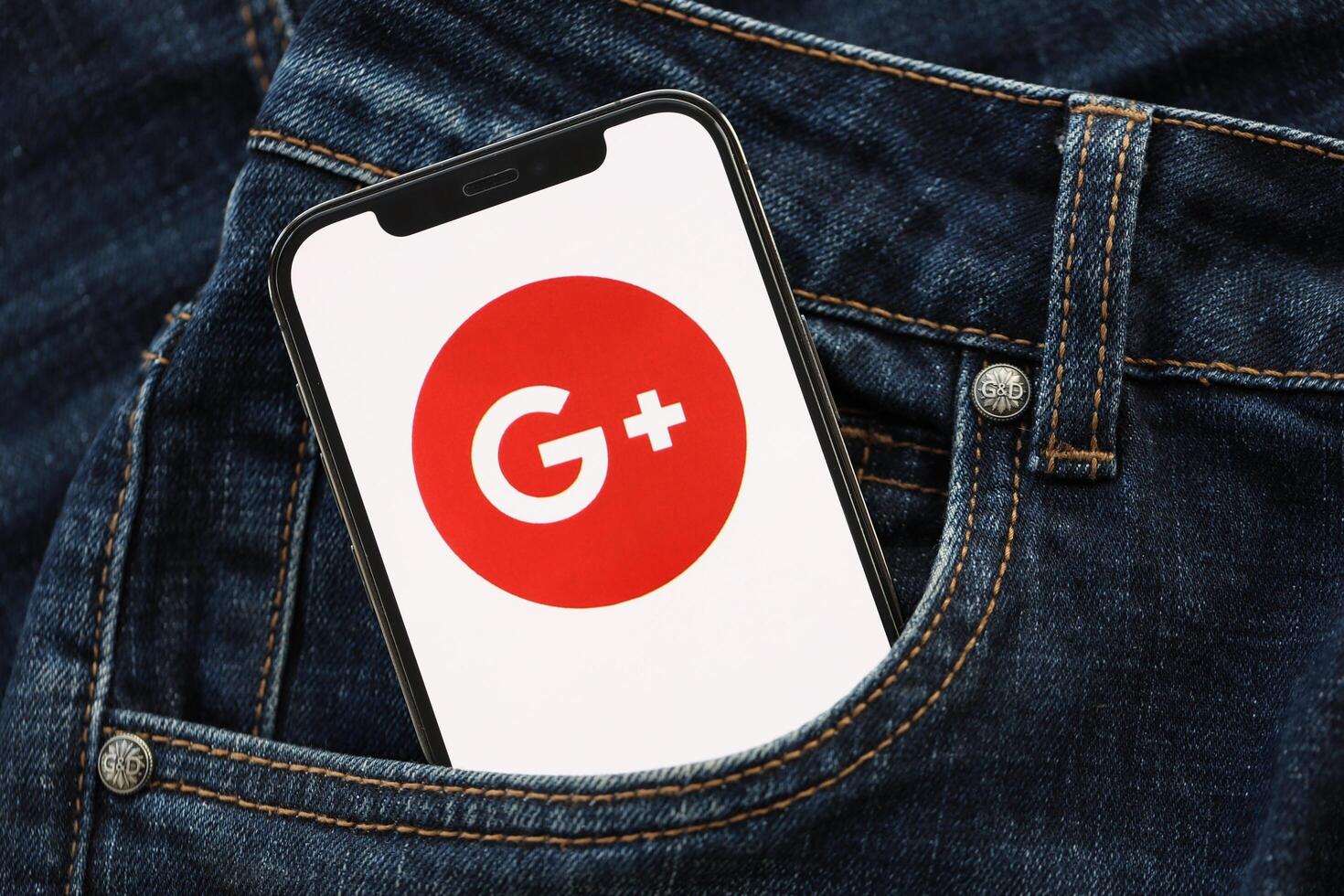 KYIV, UKRAINE - APRIL 1, 2024 Google Plus icon on smartphone display screen in jeans pocket photo