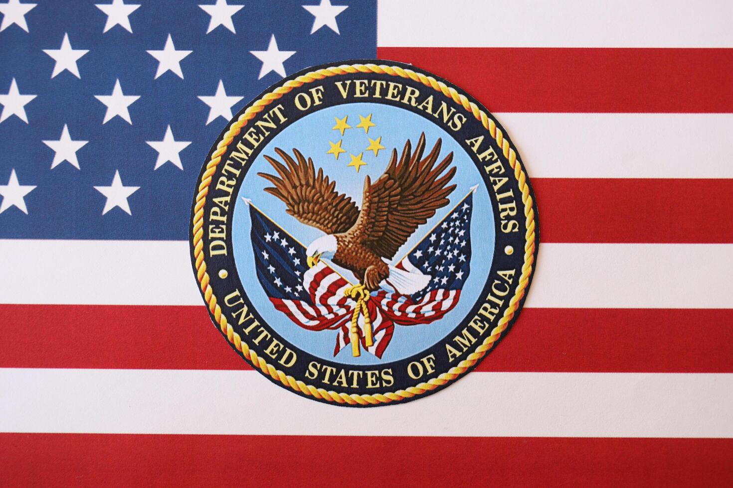 KYIV, UKRAINE - MARCH 9, 2024 US Department of Veteran Affairs seal on United States of America flag photo