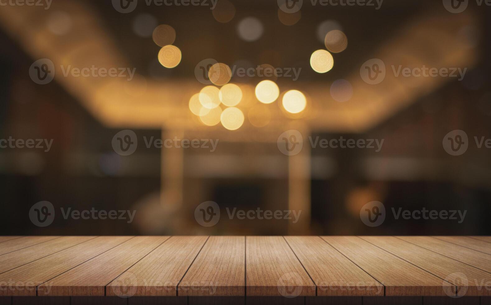 Empty wooden table top with lights bokeh on blur restaurant background. photo