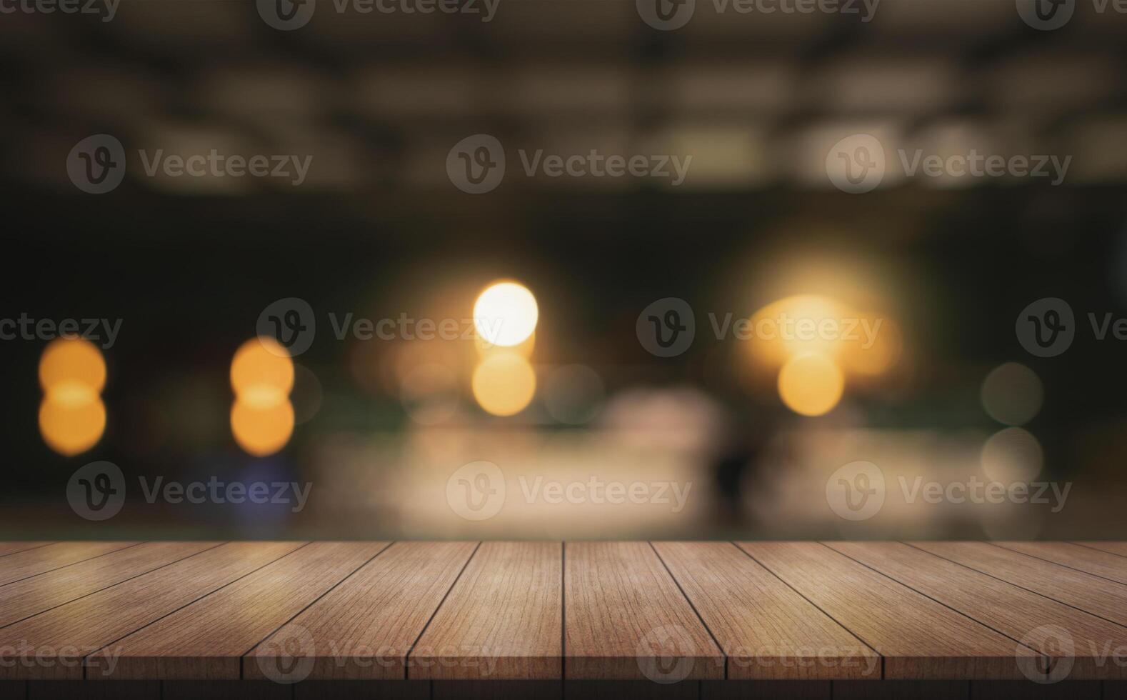 Empty wooden table top with lights bokeh on blur restaurant background. photo