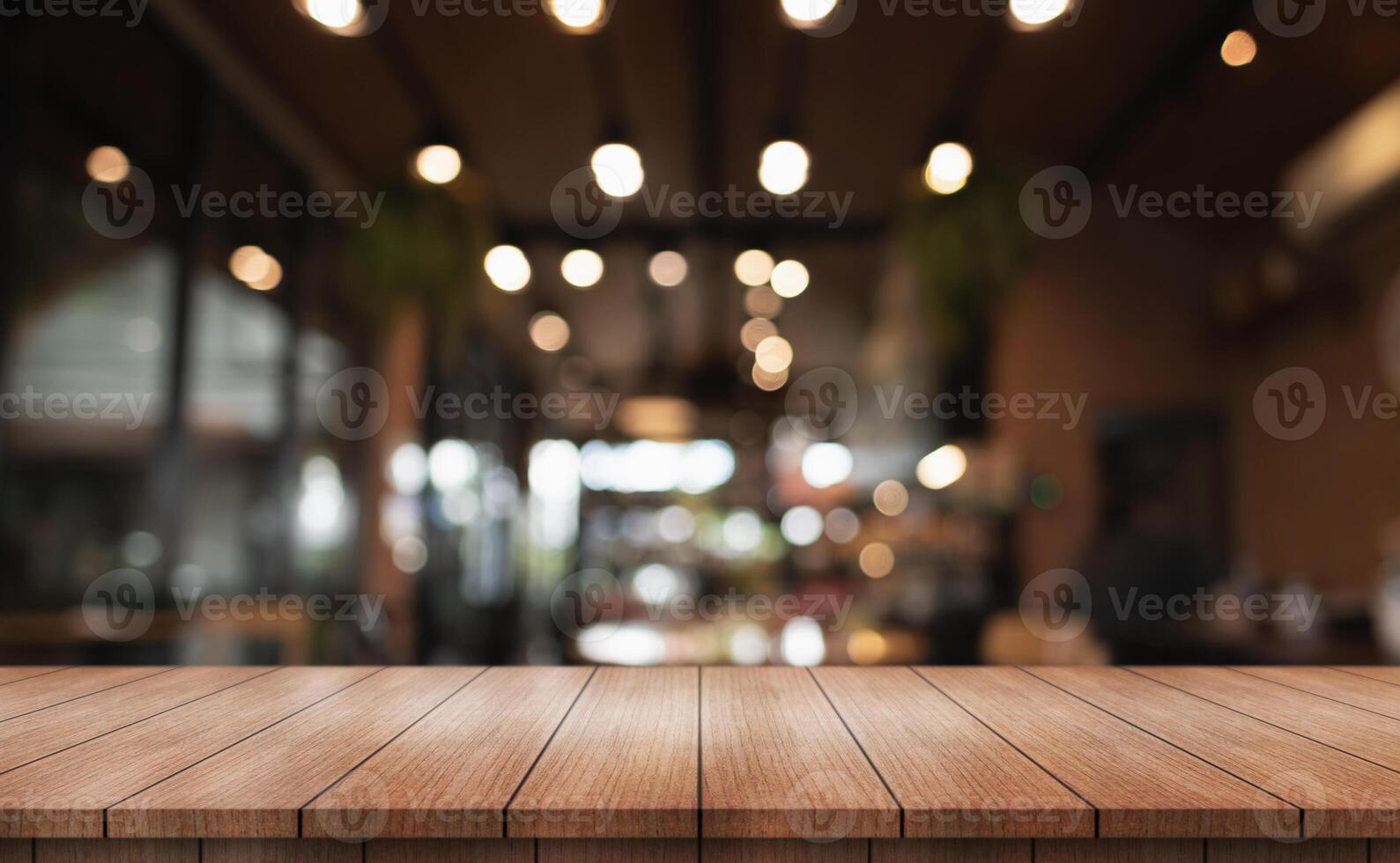 Empty wooden table top with lights bokeh on blur restaurant background. photo