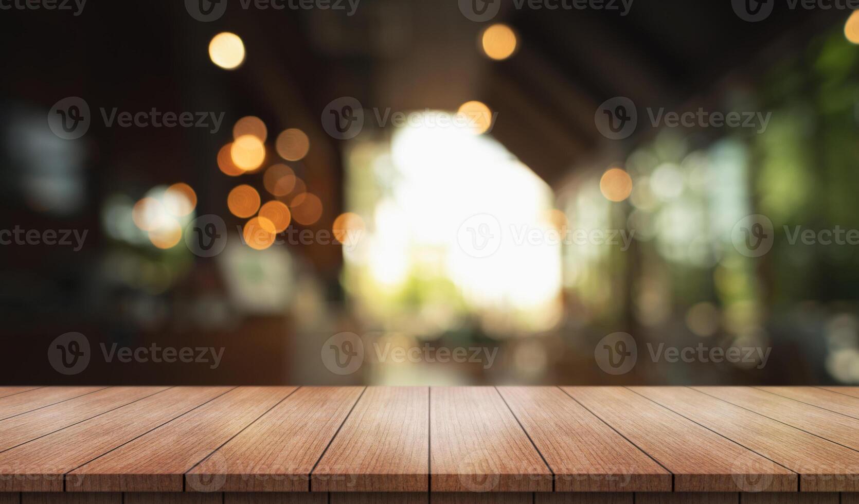 Empty wooden table top with lights bokeh on blur restaurant background. photo
