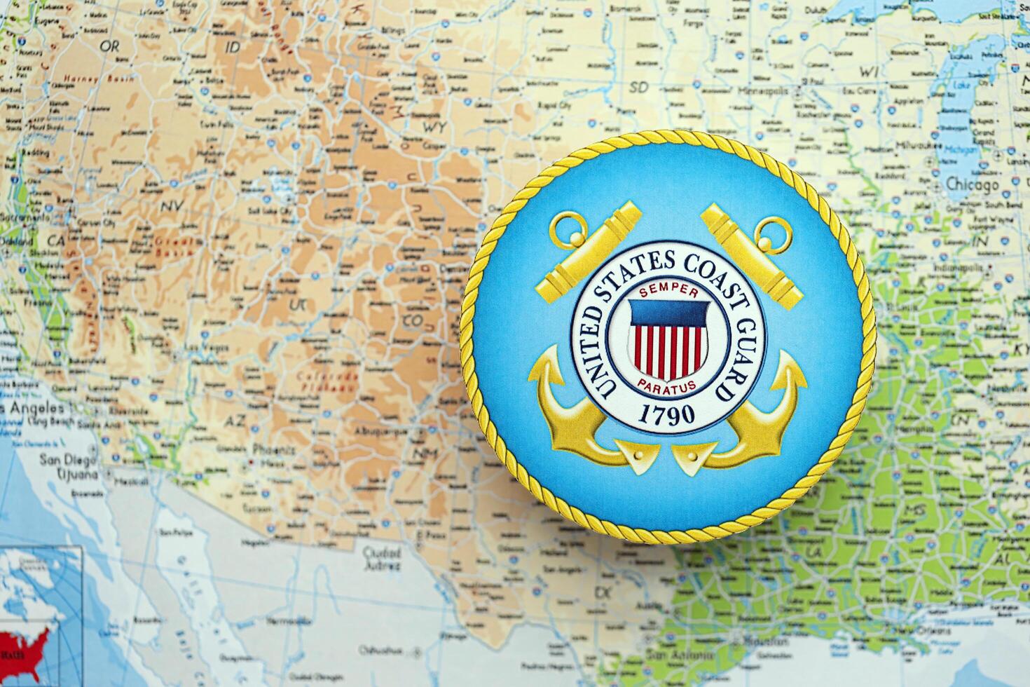 KYIV, UKRAINE - JUNE 26, 2024 United States Coast Guard coat of arms on paper map of United States photo