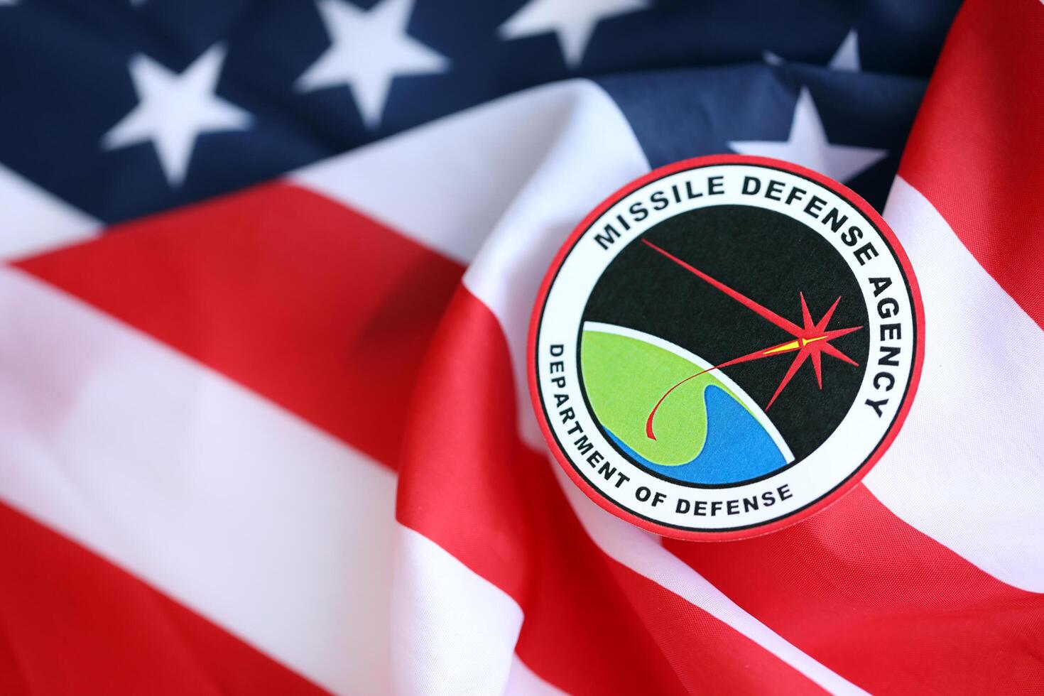 KYIV, UKRAINE - JUNE 26, 2024 Department of Defense Missile Defense Agency coat of arms sticker on folded US flag photo