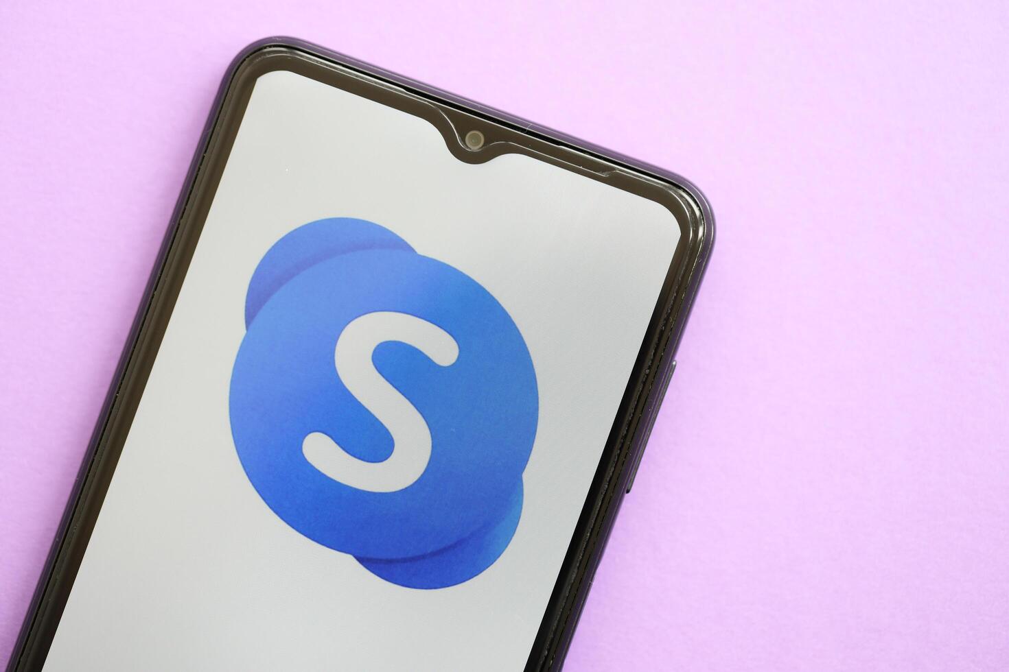 KYIV, UKRAINE - APRIL 1, 2024 Skype icon on smartphone screen on purple table photo