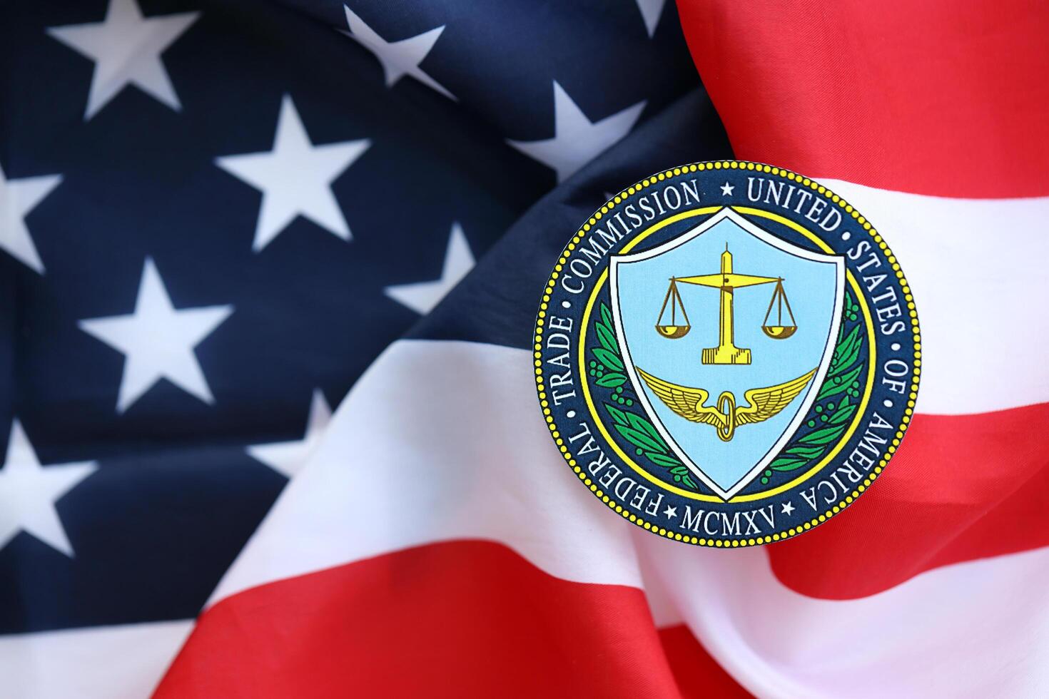 KYIV, UKRAINE - JUNE 26, 2024 United States Federal Trade Commission coat of arms sticker on folded US flag photo