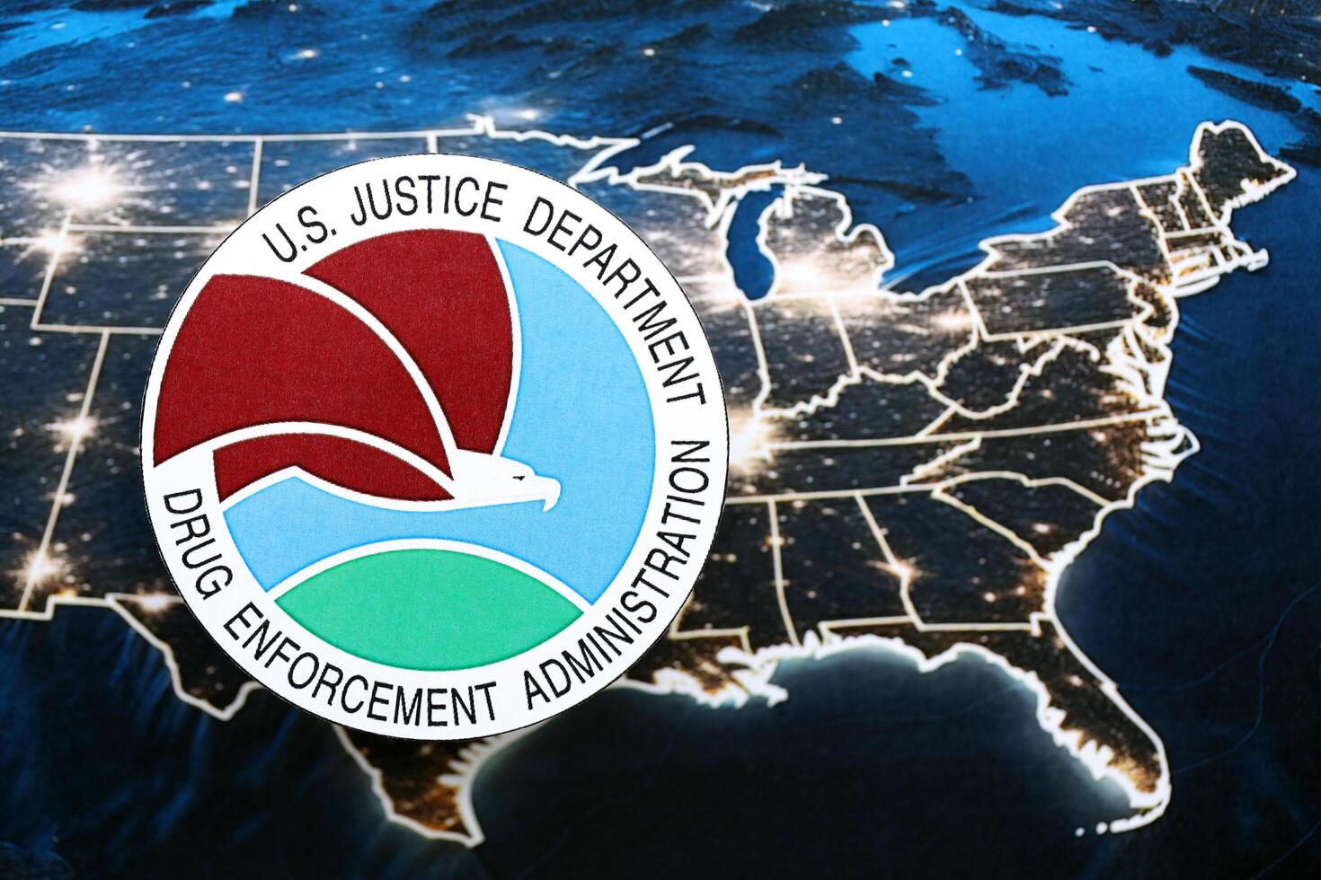 KYIV, UKRAINE - JUNE 26, 2024 U.S. Justice Department Drug Enforcement Administration coat of arms on paper map of United States photo