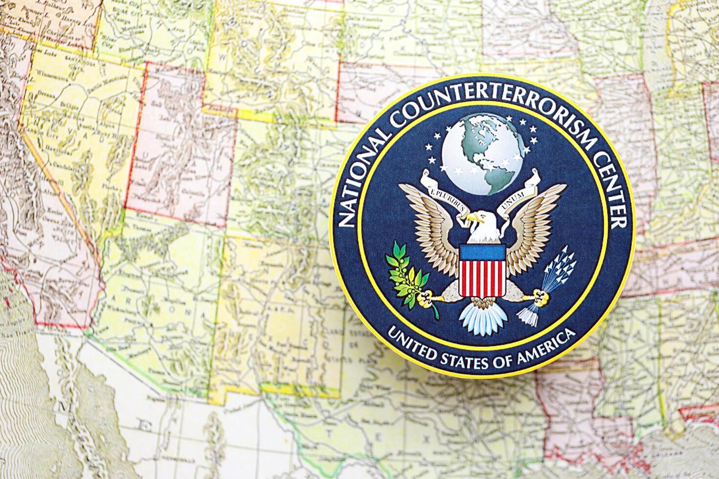 KYIV, UKRAINE - JUNE 26, 2024 United States National Counterterrorism Center coat of arms on paper map of United States photo
