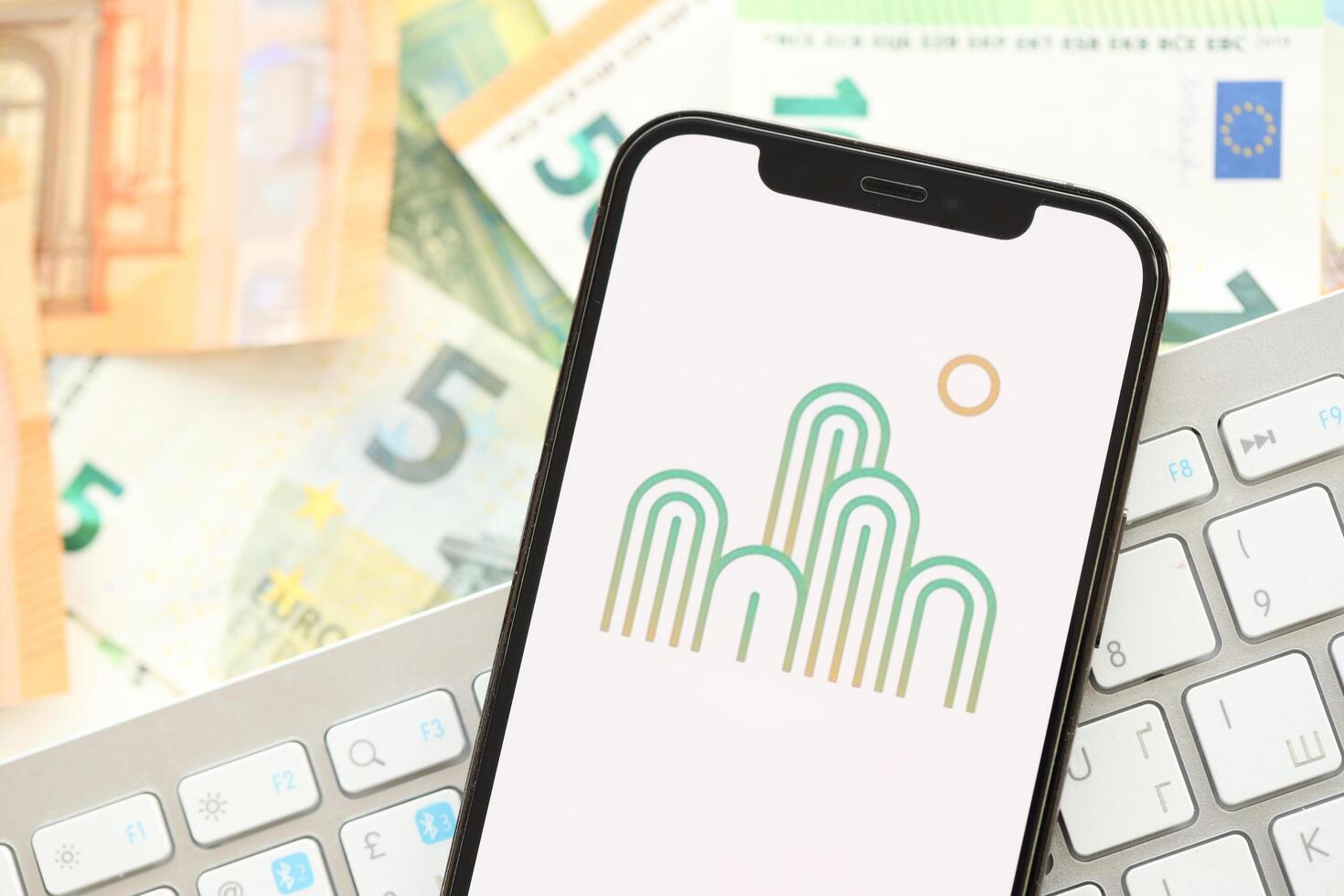 KYIV, UKRAINE - APRIL 1, 2024 Oasis icon on smartphone screen on many euro money bills photo