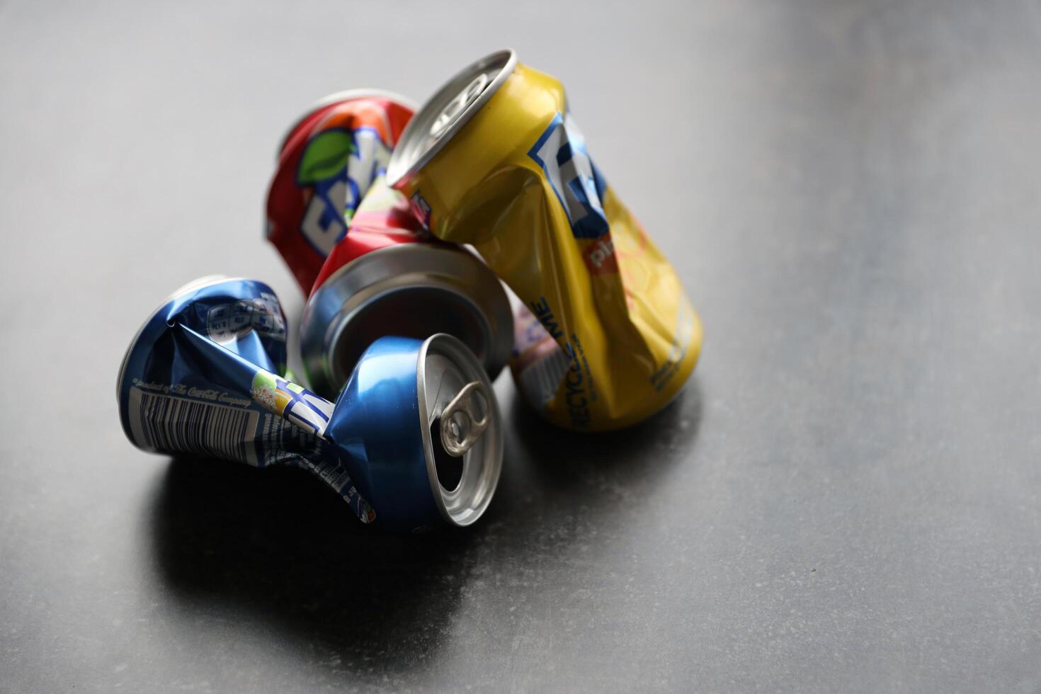 KYIV, UKRAINE - 4 MAY, 2023 Fanta soft drink brand crumpled tin cans with various flavours photo