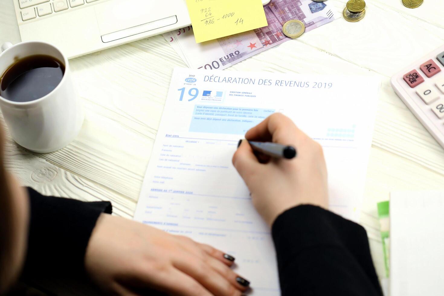 KYIV, UKRAINE - OCTOBER 31, 2023 Accountant fill french tax form 2042 income statement in end of tax period. Taxation and paperwork routine photo