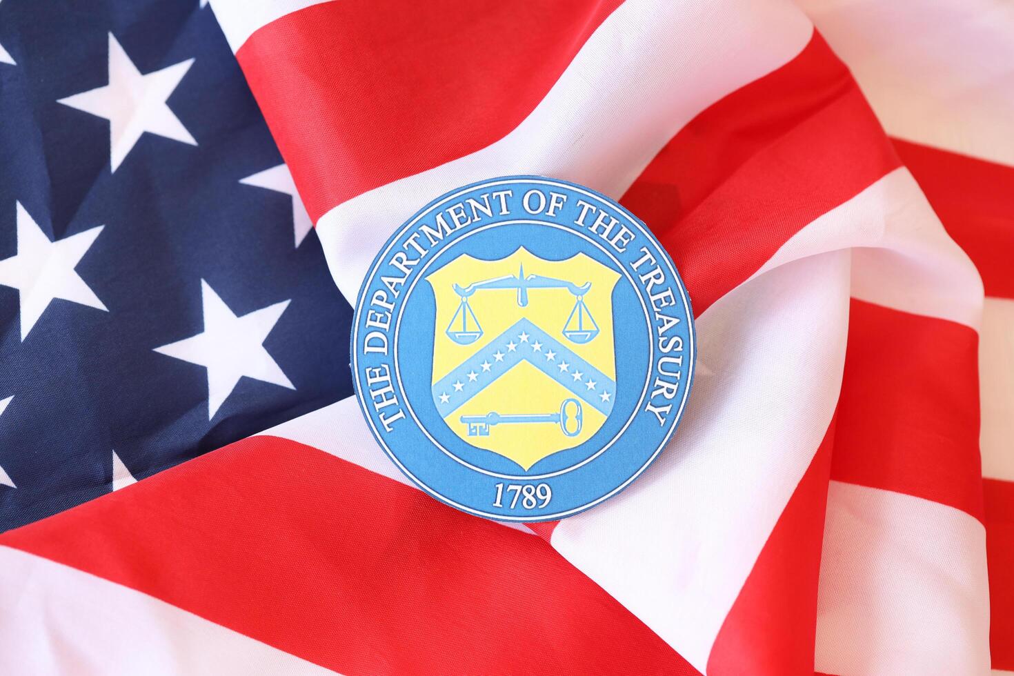 KYIV, UKRAINE - MARCH 9, 2024 US The Department of the Treasury seal on United States of America flag photo