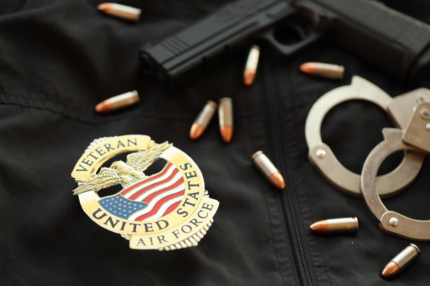 KYIV, UKRAINE - MARCH 9, 2024 US Air Force Veteran badge on black jacket uniform with gun, bullets and handcuffs photo