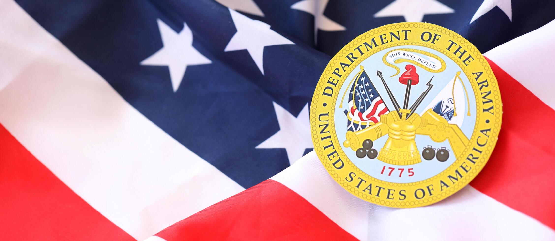 KYIV, UKRAINE - MARCH 9, 2024 US Department of Army seal on United States of America flag photo