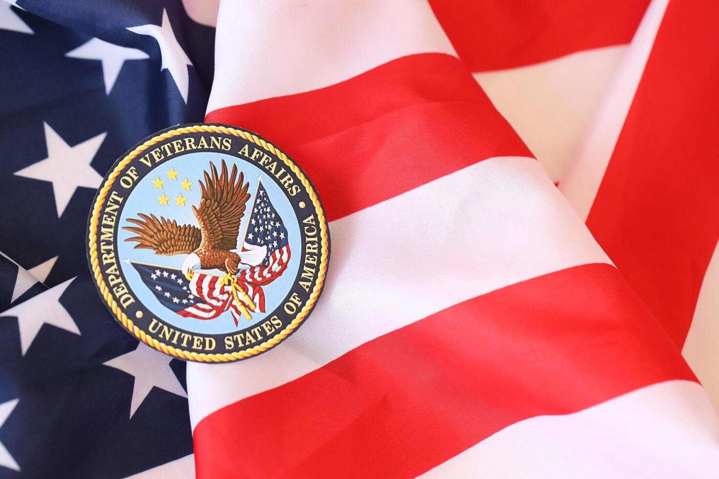 KYIV, UKRAINE - MARCH 9, 2024 US Department of Veteran Affairs seal on United States of America flag photo