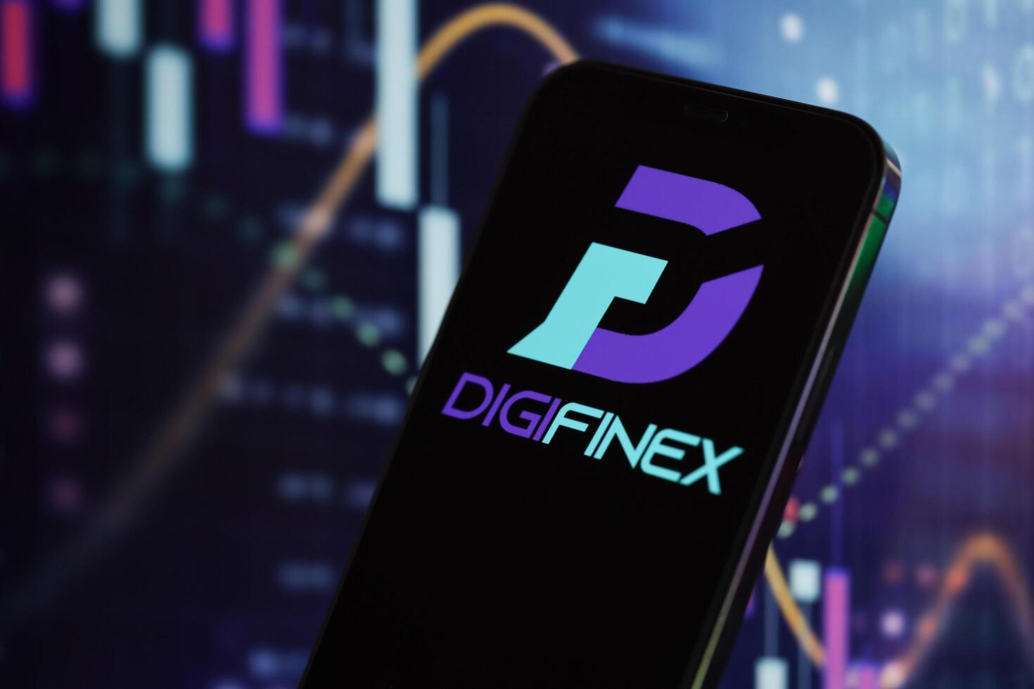 KYIV, UKRAINE - MARCH 15, 2024 Digifinex logo on iPhone display screen and crypto currency value charts photo
