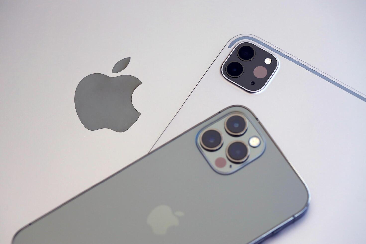 KYIV, UKRAINE - 4 MAY, 2023 Apple brand devices iphone and ipad lies on macbook body photo