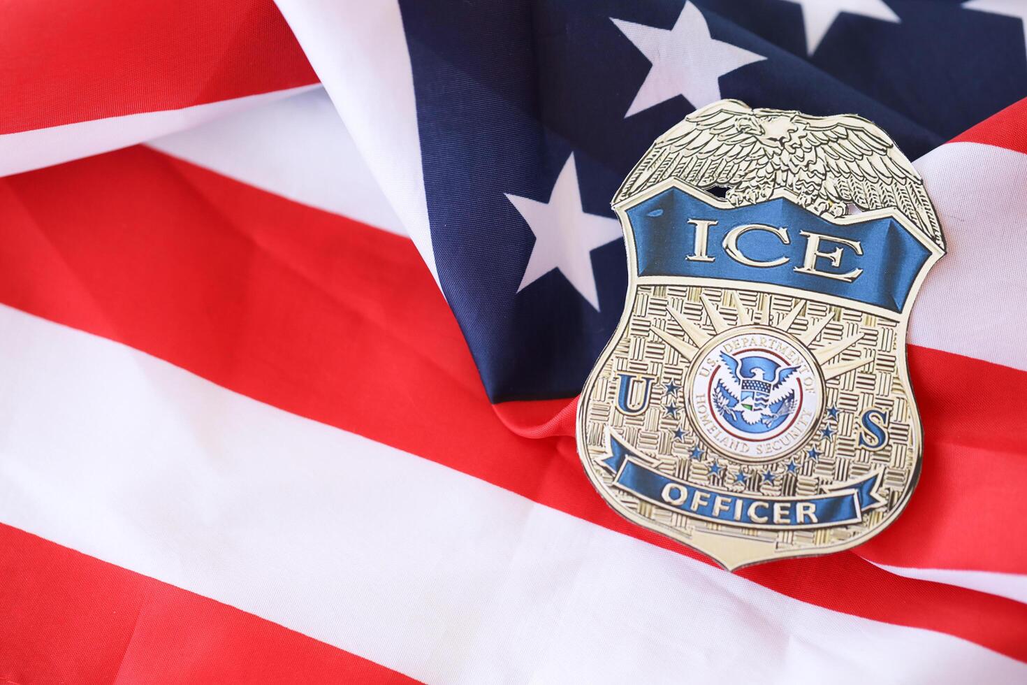 KYIV, UKRAINE - MARCH 9, 2024 US ICE Officer badge on United States of America flag photo