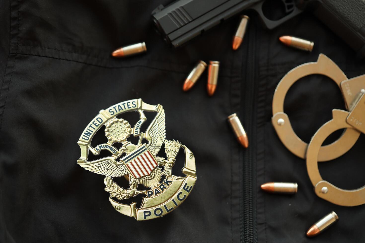 KYIV, UKRAINE - MARCH 9, 2024 US United States Park Police badge on black jacket uniform with gun, bullets and handcuffs photo