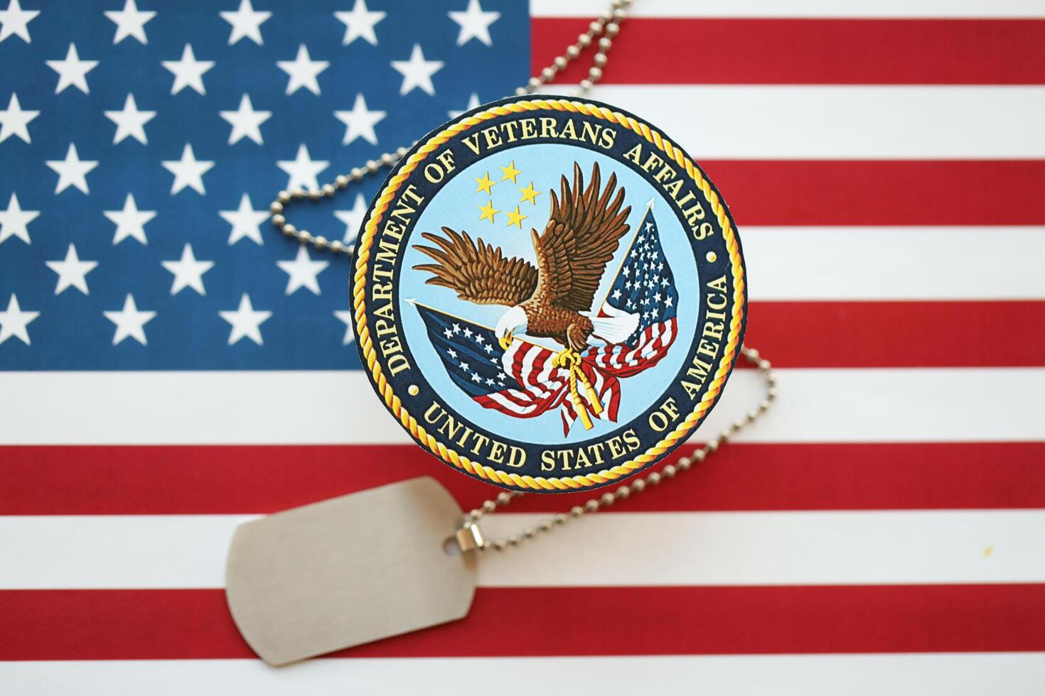 KYIV, UKRAINE - MARCH 9, 2024 US Department of Veteran Affairs seal with dogtags on United States of America flag photo
