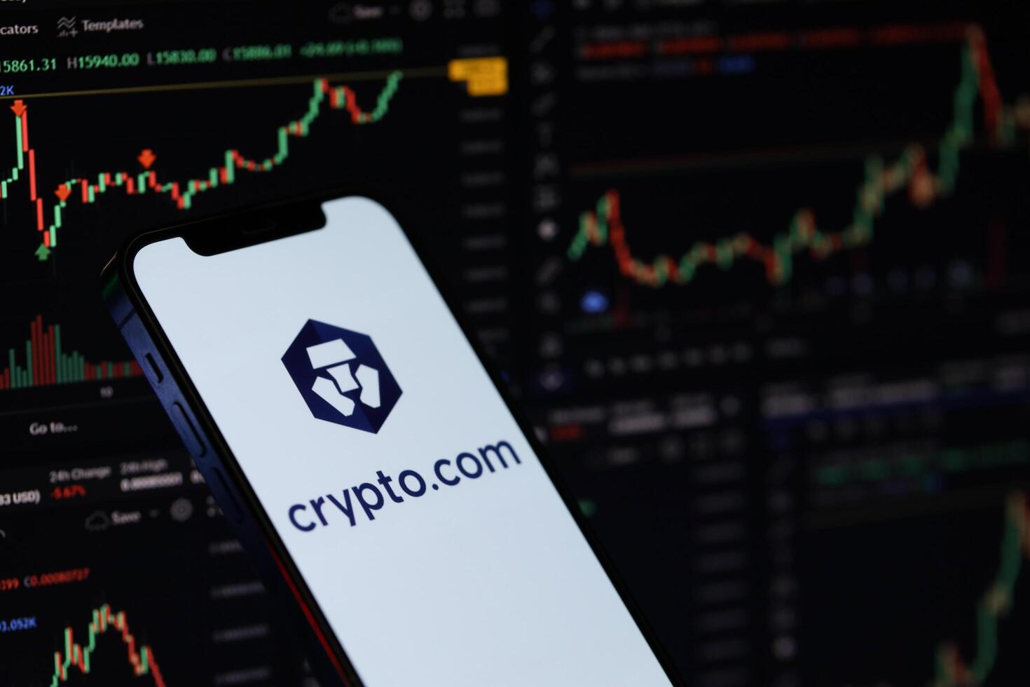 KYIV, UKRAINE - MARCH 15, 2024 Crypto com logo on iPhone display screen and crypto currency value charts photo