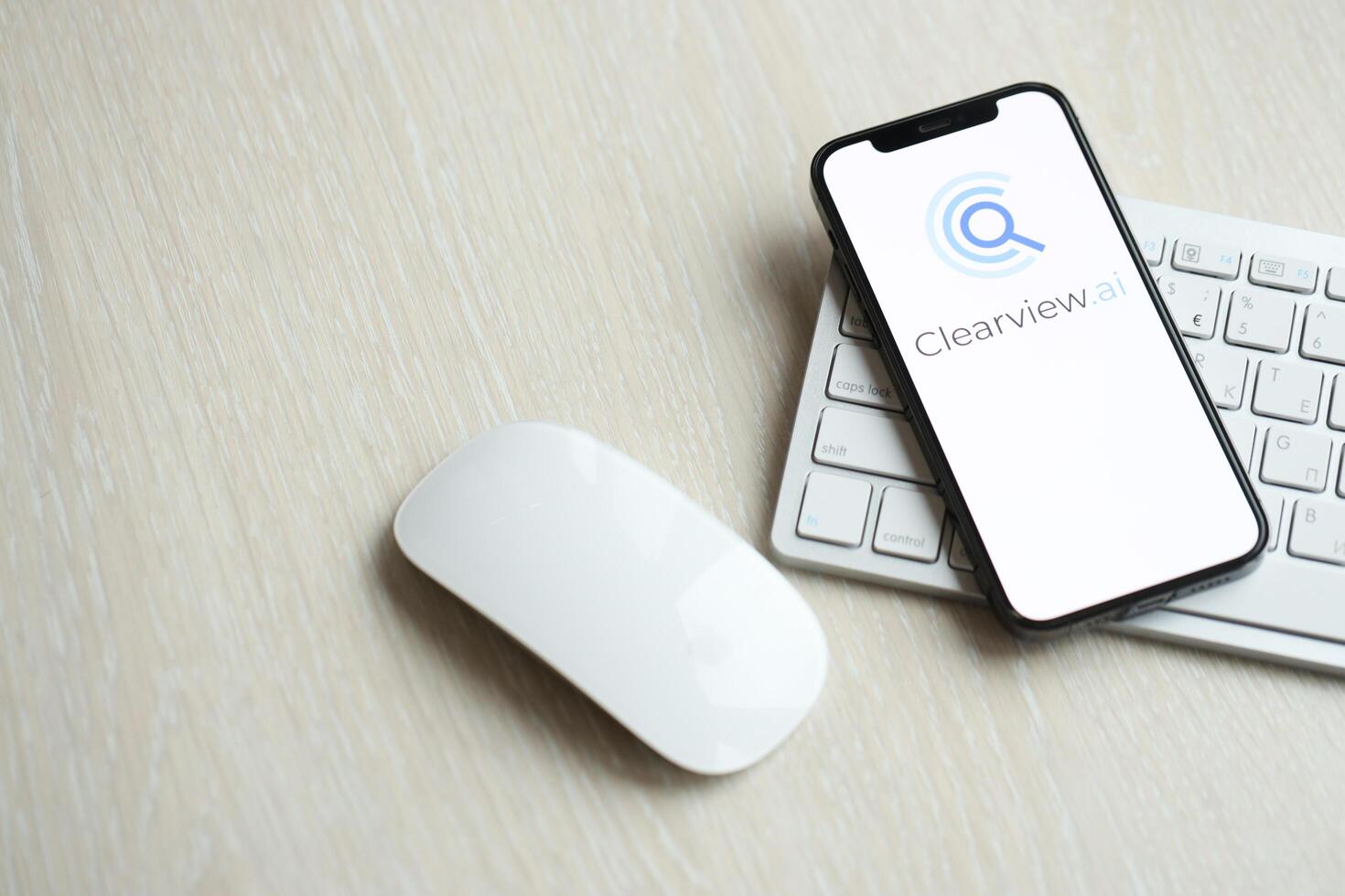 KYIV, UKRAINE - MARCH 17, 2024 ClearView logo on iPhone display screen with apple keyboard and mouse on table photo