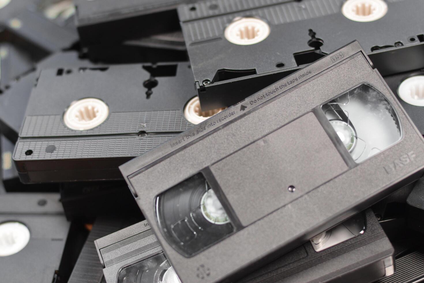 KYIV, UKRAINE - 4 MAY, 2023 tape on colored background, VHS, cassette. Messy stack of VHS tapes. Home System tape photo