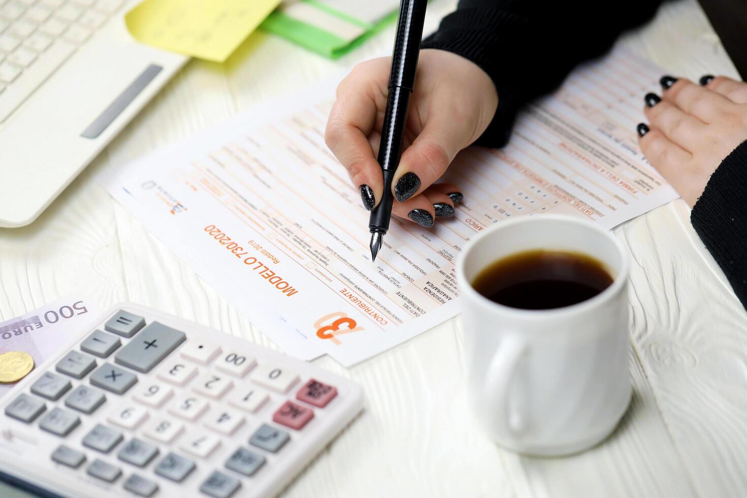 KYIV, UKRAINE - OCTOBER 31, 2023 Accountant fill italian tax form Modello 730 individual income tax return in end of tax period. Taxation and paperwork routine photo