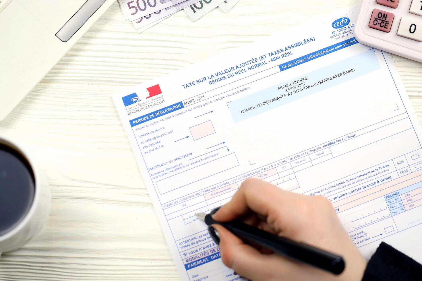 KYIV, UKRAINE - OCTOBER 31, 2023 Accountant fill french tax form 10963 Value added tax and similar taxes in end of tax period. Taxation and paperwork routine photo