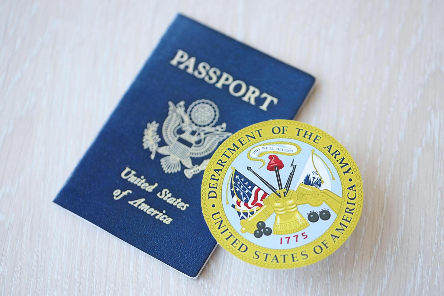 KYIV, UKRAINE - MARCH 9, 2024 US Department of Army seal and United States passport on wooden table photo