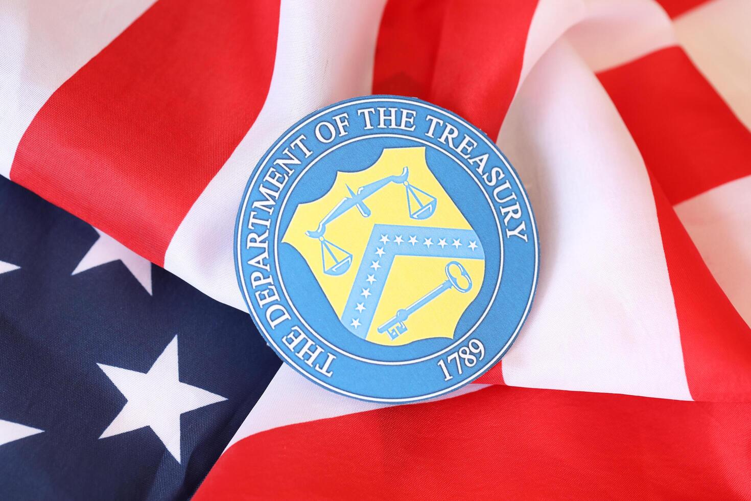 KYIV, UKRAINE - MARCH 9, 2024 US The Department of the Treasury seal on United States of America flag photo
