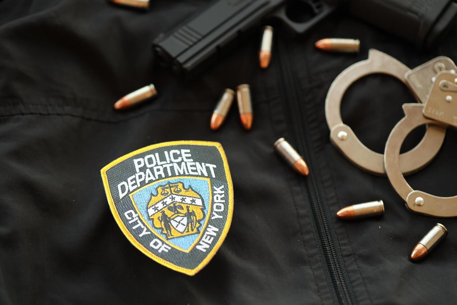 KYIV, UKRAINE - MARCH 9, 2024 US NYPD Police patch on black jacket uniform with gun, bullets and handcuffs photo
