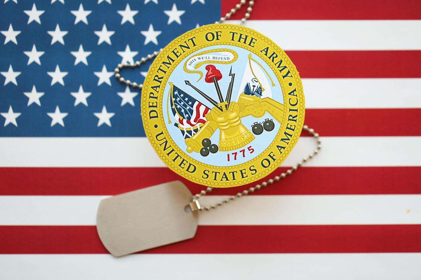 KYIV, UKRAINE - MARCH 9, 2024 US Department of Army seal with dogtags on United States of America flag photo