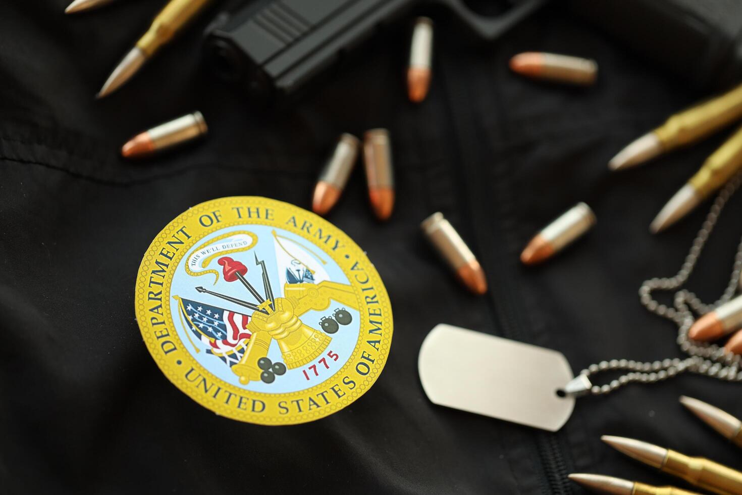KYIV, UKRAINE - MARCH 9, 2024 US Department of Army seal on black jacket uniform with gun, bullets and dogtags photo