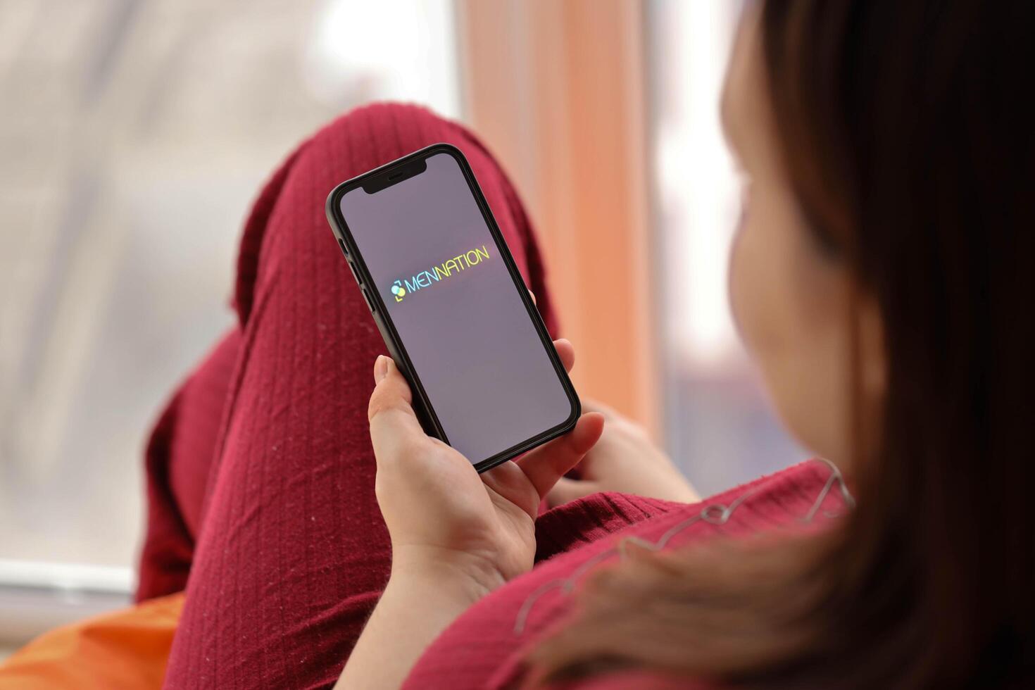 KYIV, UKRAINE - FEBRUARY 23, 2024 Mennation logo of famous dating website or app on iPhone display photo