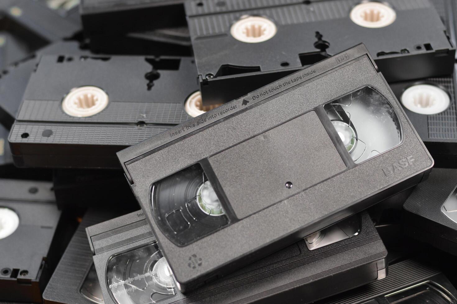 KYIV, UKRAINE - 4 MAY, 2023 tape on colored background, VHS, cassette. Messy stack of VHS tapes. Home System tape photo
