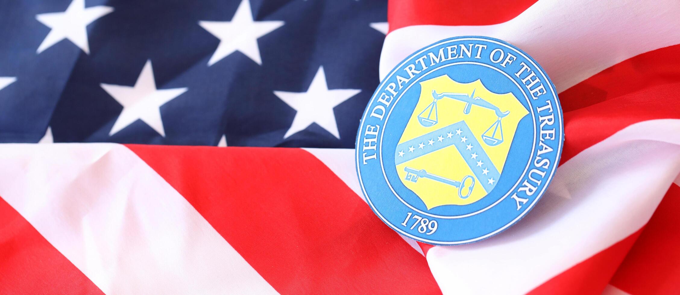 KYIV, UKRAINE - MARCH 9, 2024 US The Department of the Treasury seal on United States of America flag photo
