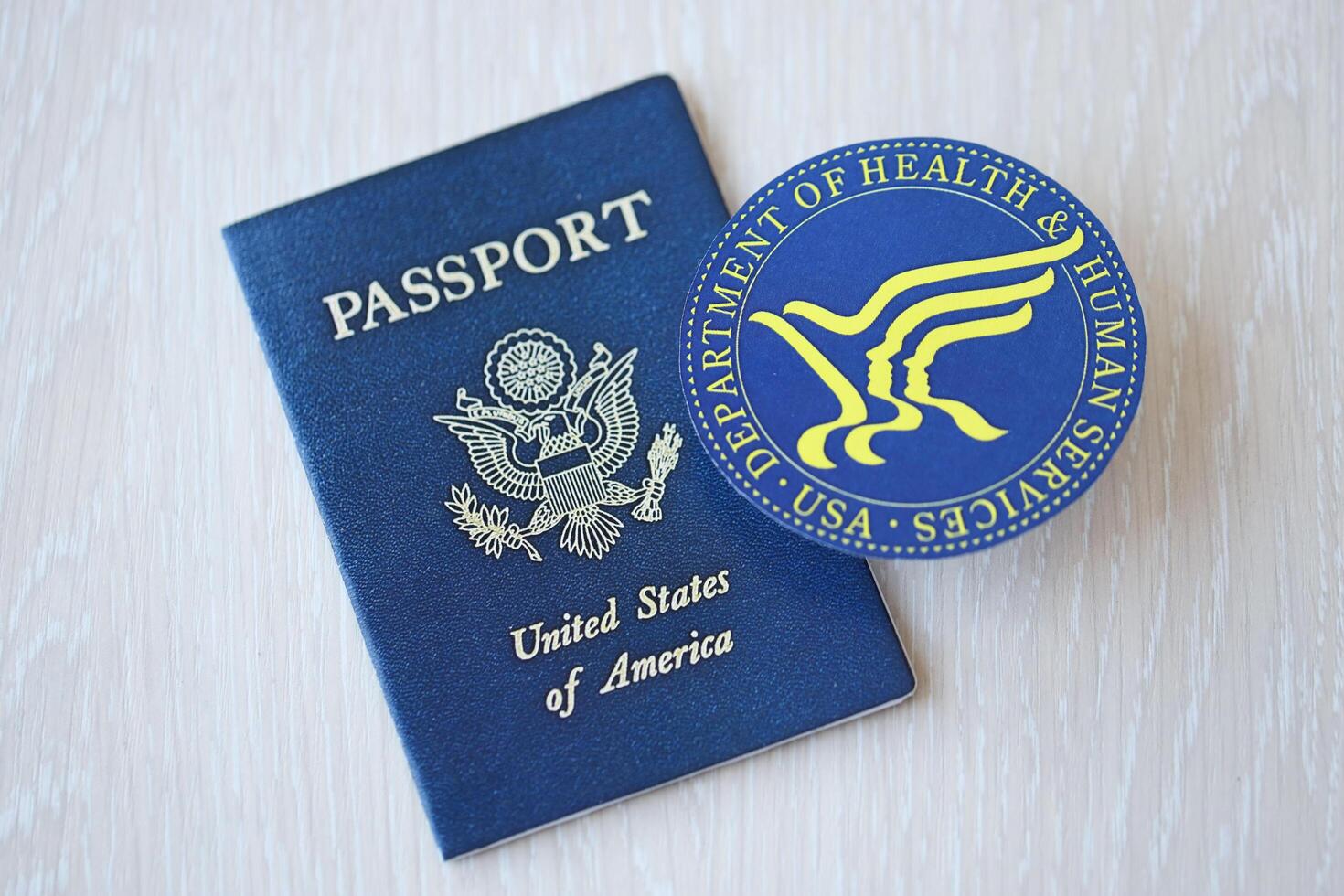 KYIV, UKRAINE - MARCH 9, 2024 US Department of Health and human Services seal and United States passport on wooden table photo
