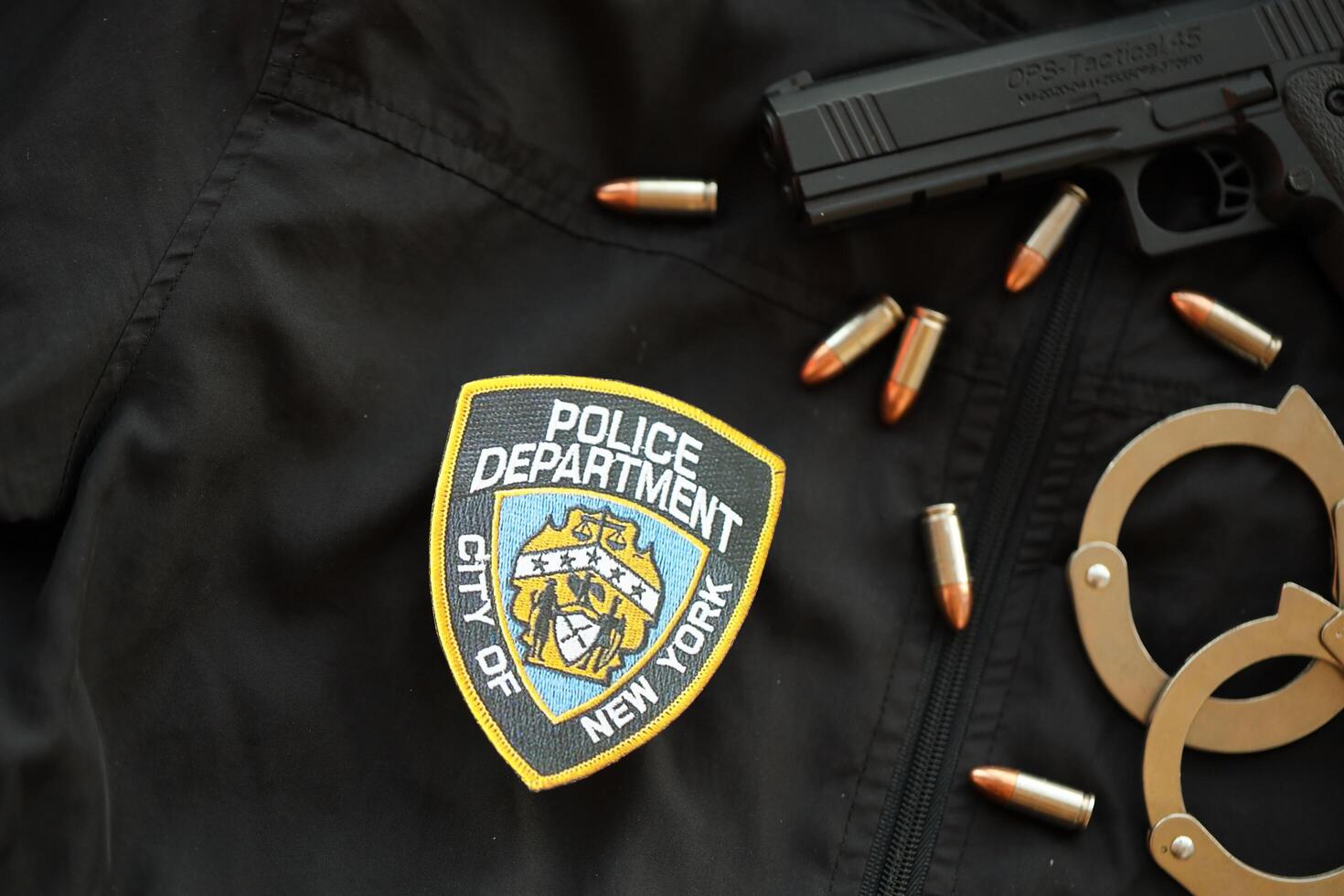 KYIV, UKRAINE - MARCH 9, 2024 US NYPD Police patch on black jacket uniform with gun, bullets and handcuffs photo