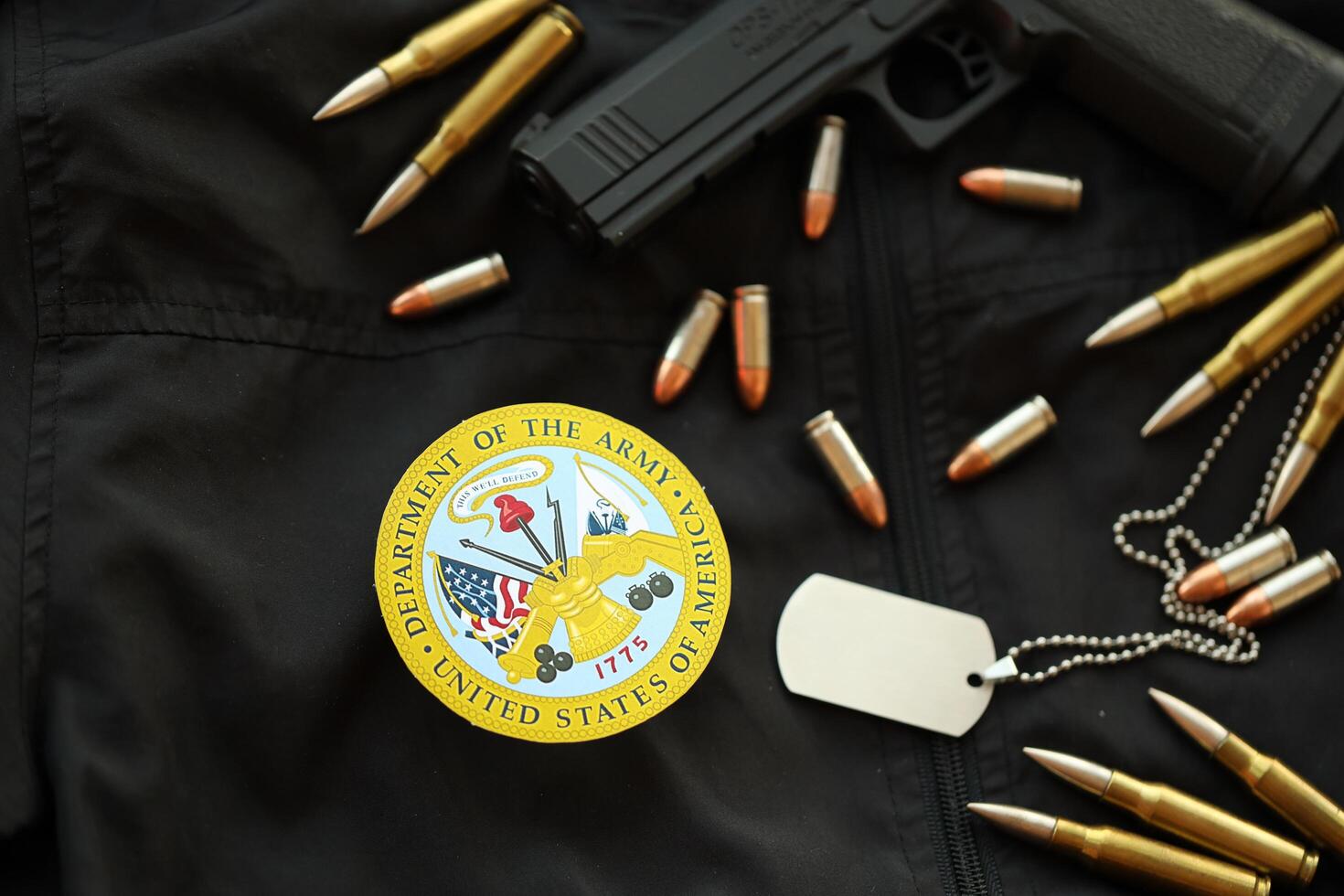 KYIV, UKRAINE - MARCH 9, 2024 US Department of Army seal on black jacket uniform with gun, bullets and dogtags photo